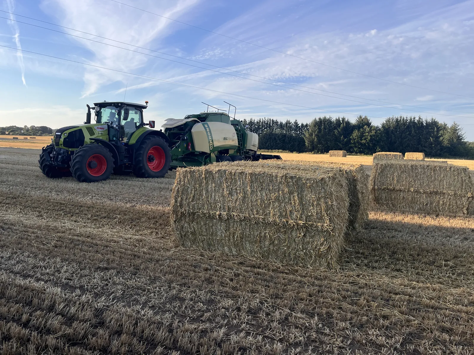 Claas Axion med Krone BiG Pack og firkantede storballer på stubmarken